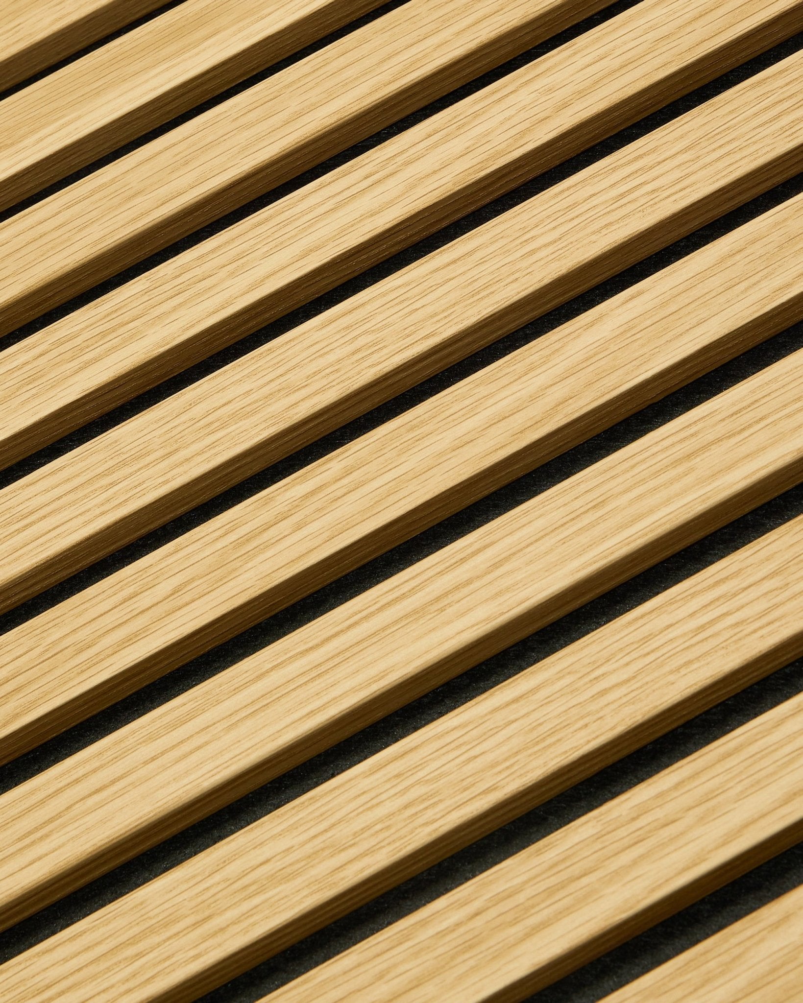 Close-up of WoodUpp Akupanel acoustic panel in Southern Oak, 240x60 cm, featuring diagonal slats and dark acoustic gaps for enhanced sound absorption.