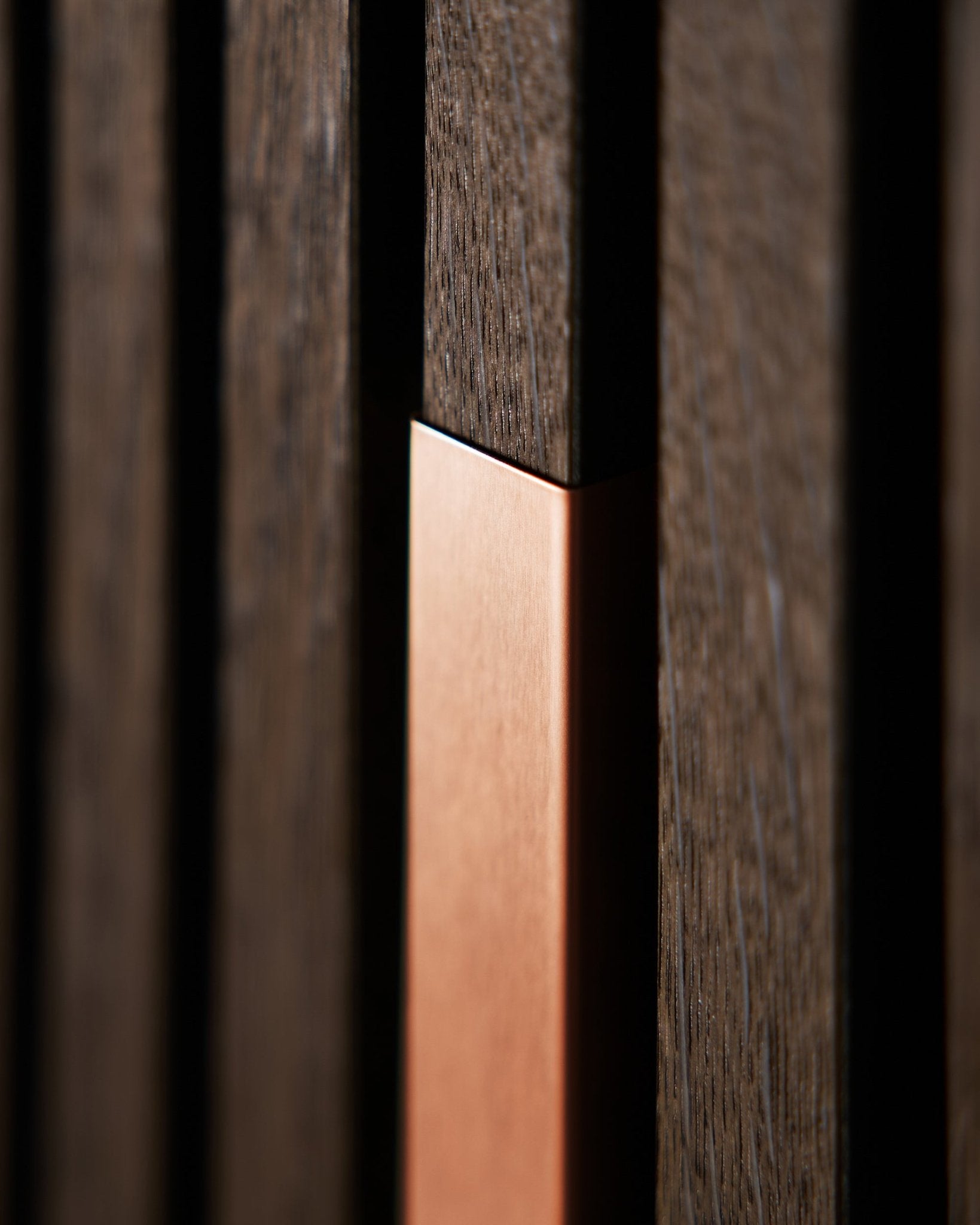Close-up of WoodUpp Akupanel Liva | Cover in Copper, 60 cm, showing vertical acoustic wooden slats with copper accent for texture and contrast.