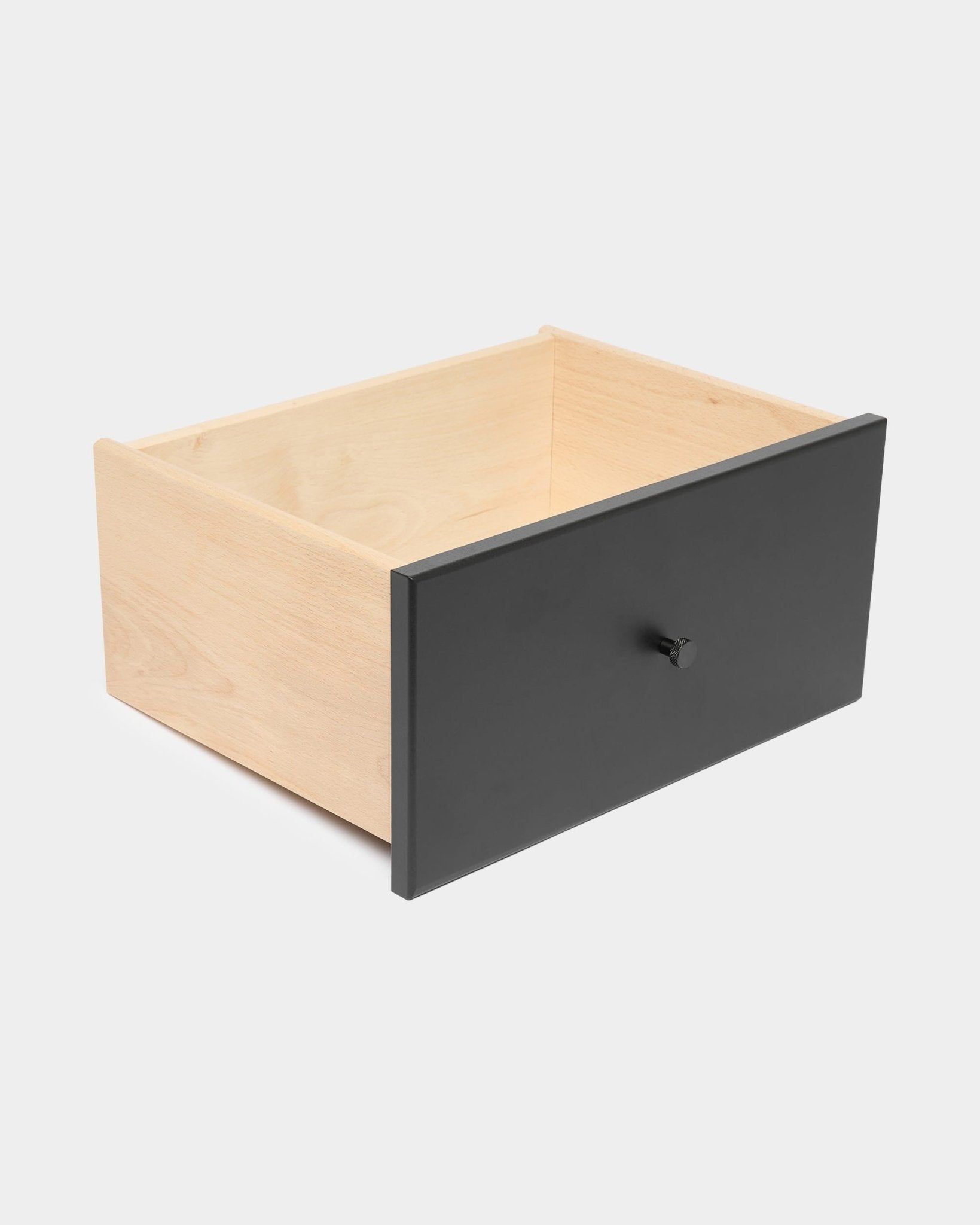 WoodUpp Arka black bookcase drawer with round knob, providing closed storage, displayed against a plain white background.
