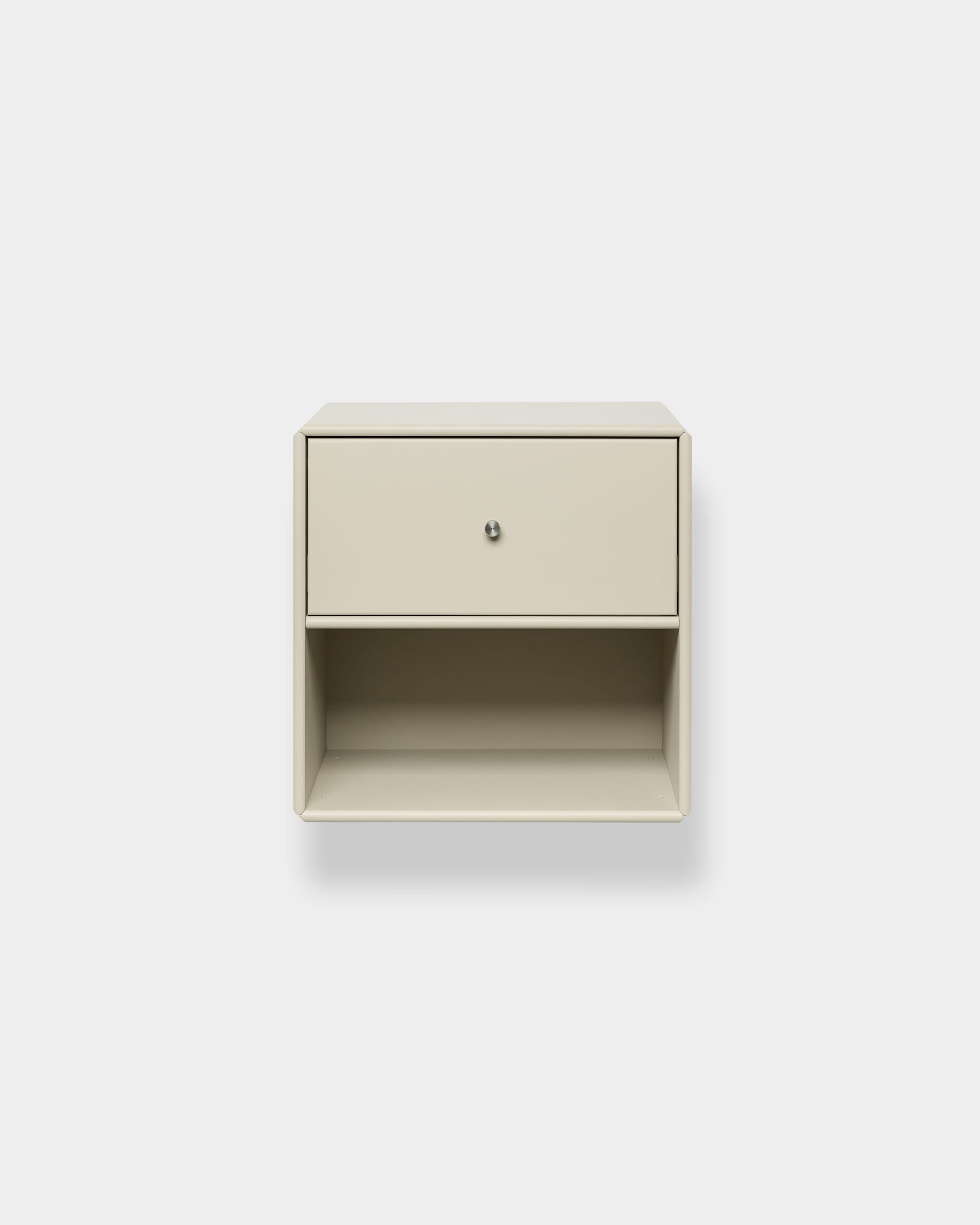 Bibliothèque Arka beige avec tiroir de la marque WoodUpp, fixée au mur, dotée dun tiroir supérieur et dune étagère ouverte, ainsi que dun espace de rangement fermé, sur fond blanc uni.