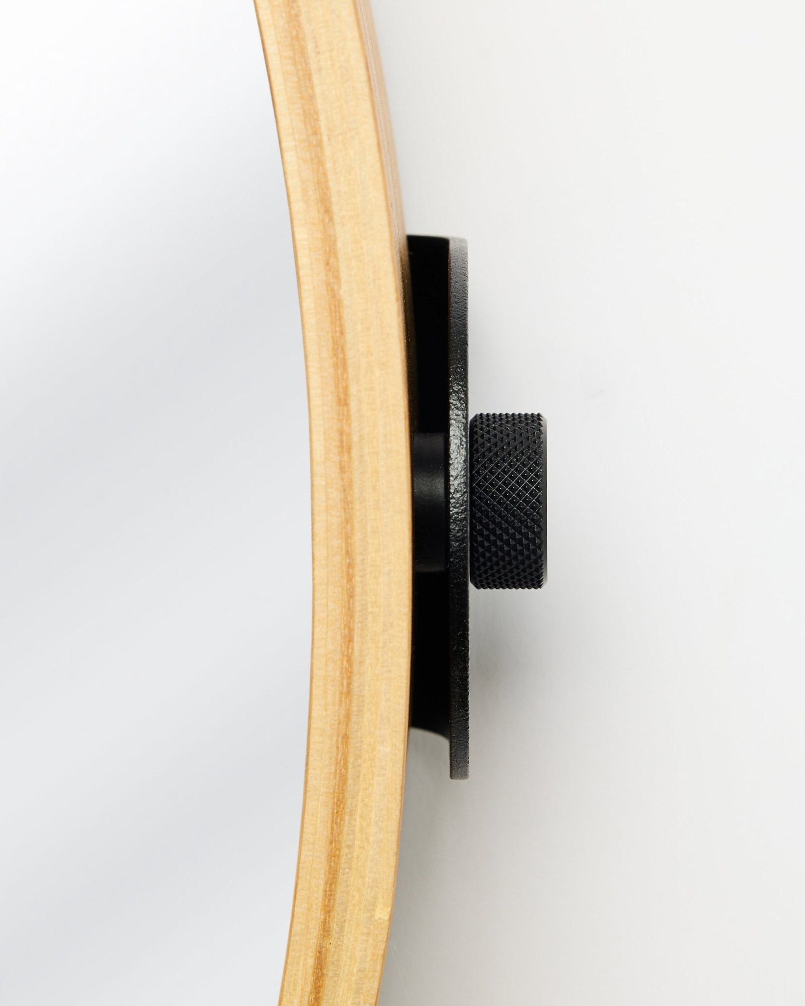 Close-up side view of the WoodUpp Linn | Mirror in Natural Oak, featuring a round oak frame and black metal knob, accessory for acoustic wood panels.