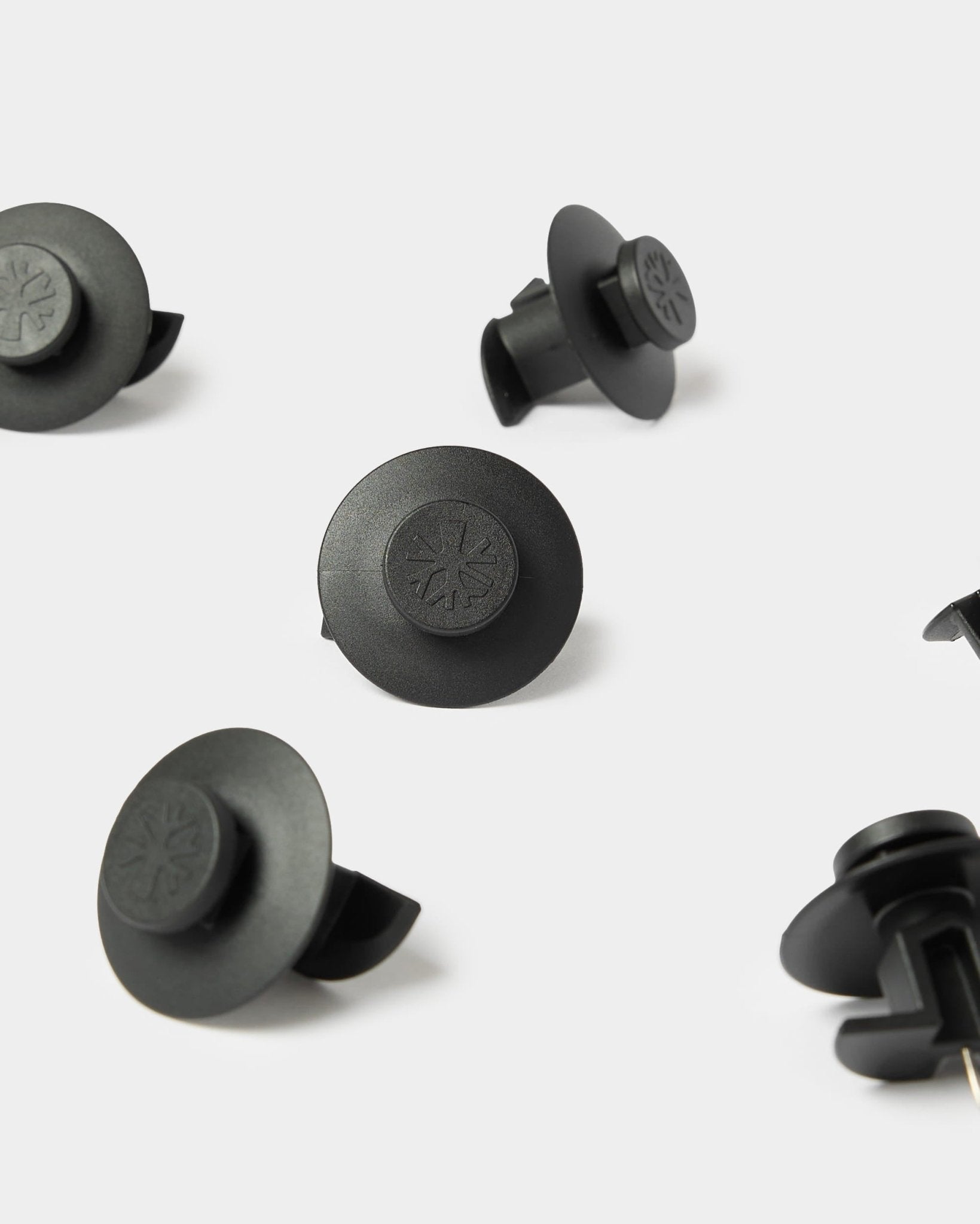 10 black Dupps fasteners by WoodUpp, compatible with Akupanel acoustic panels for secure mounting. Embossed symbols on durable plastic.