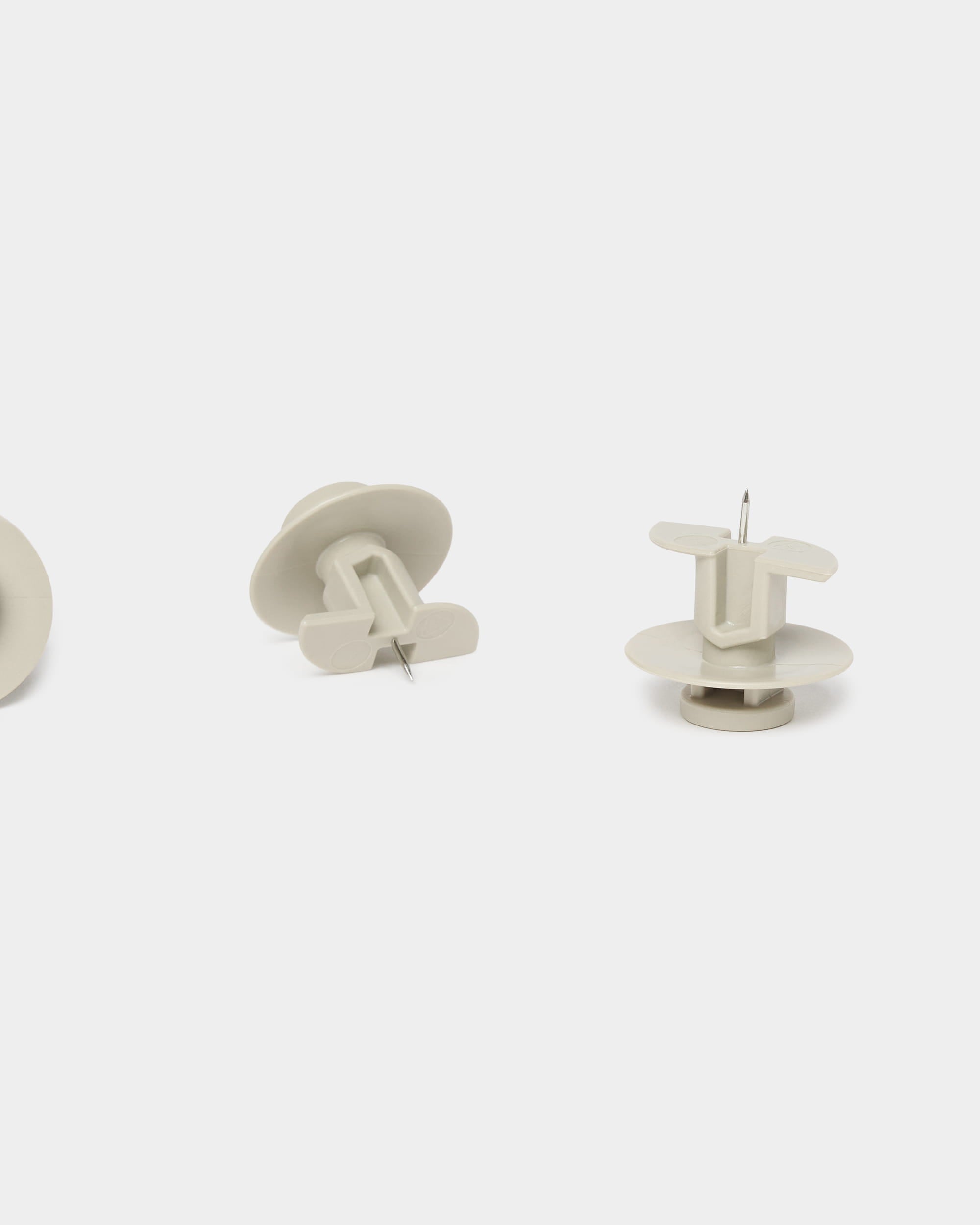 Set of three beige WoodUpp Dupps push pins and tool, designed for Akupanel acoustic panels, displayed upright and sideways on a plain white background.
