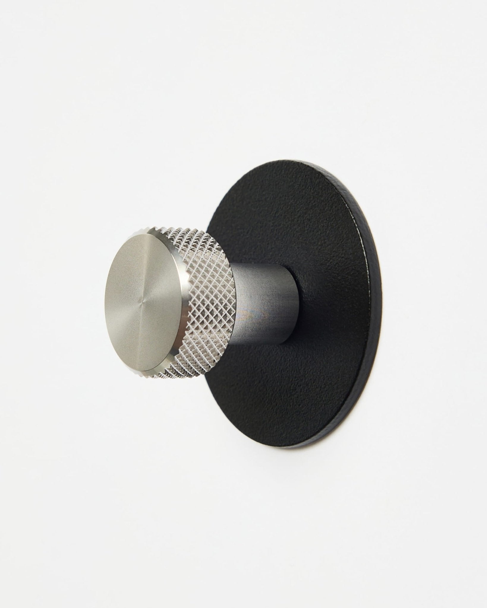 WoodUpp Norr | Coat Hook X1 in black and stainless steel installed on a plain white wall, designed as a CREATE collection accessory for Akupanel systems.
