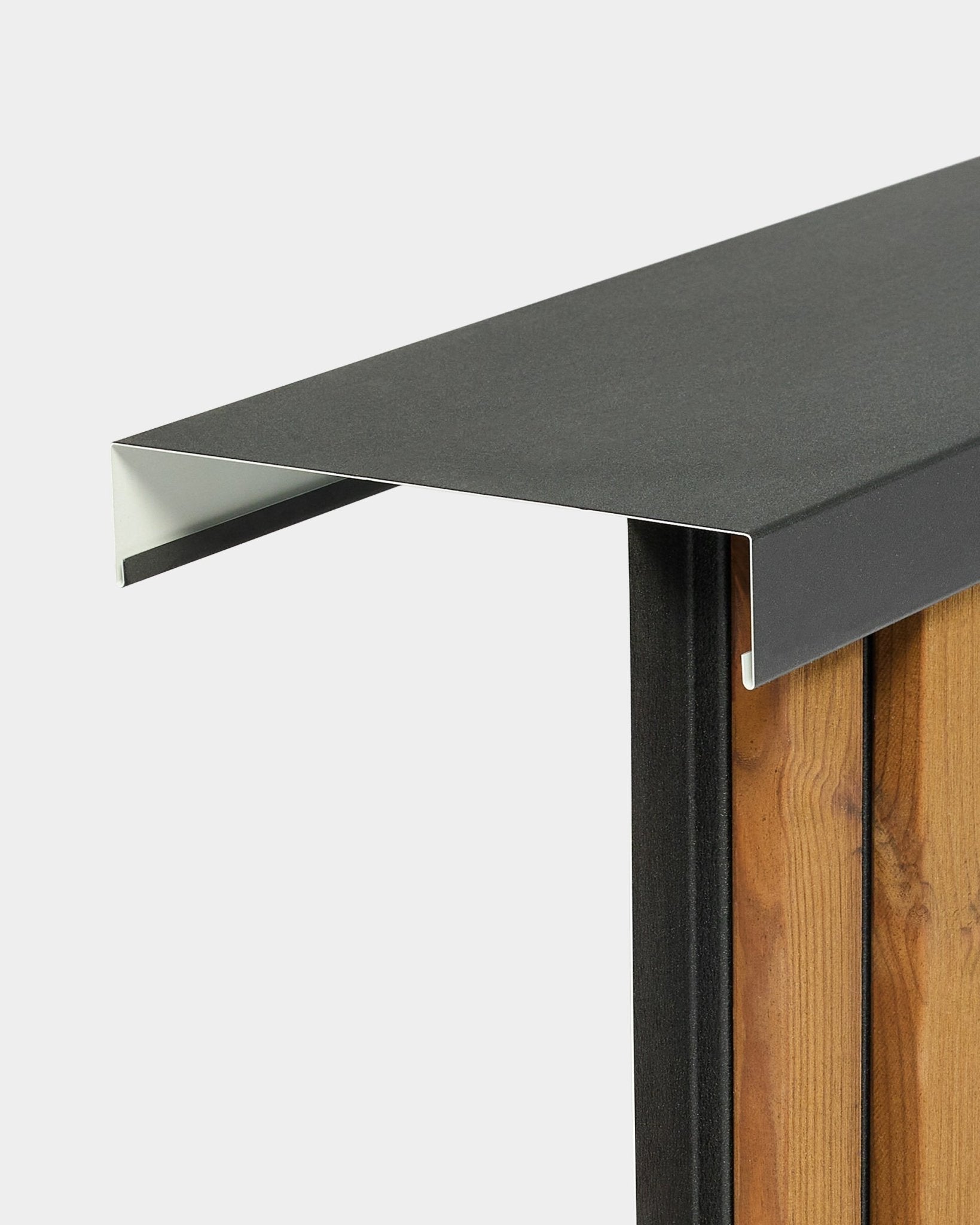 Close-up of WoodUpp Aluwood Level Wall Capping (240 cm x 25 cm) installed on vertical facade panels, highlighting edge detail against a plain background.